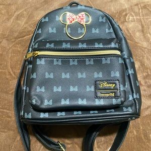 Loungefly Minnie Mouse themed backpack with gold accents